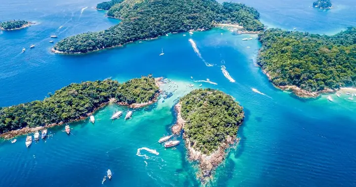 Vista aérea de ilhas e canais de água azul com lanchas navegando e ancoradas